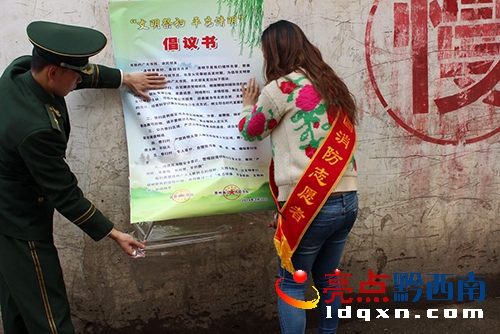 黔西南消防志愿者配合消防官兵在社區(qū)旁張貼倡議書.jpg