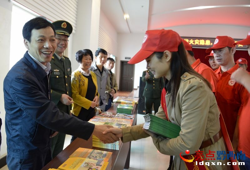 州委常委、州政府副州長(zhǎng)周登濤向消防志愿者贈(zèng)送資料并握手慰問(wèn).jpg
