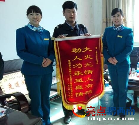 普安江西坡收費站站長蔣詠玲、副站長劉寬麗將錦旗送到普安汽車站職工吳小龍手中.jpg