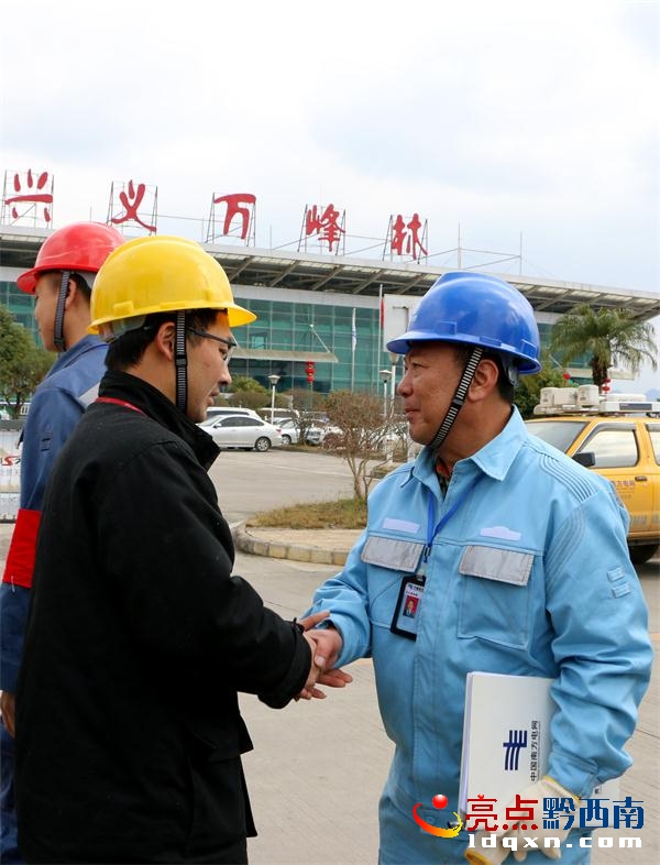 萬峰林機場工作人員緊握興義供電局城區(qū)分局“心意電”服務隊隊員的手,對他們的優(yōu)質(zhì)服務表示謝意(盧關文 攝).JPG