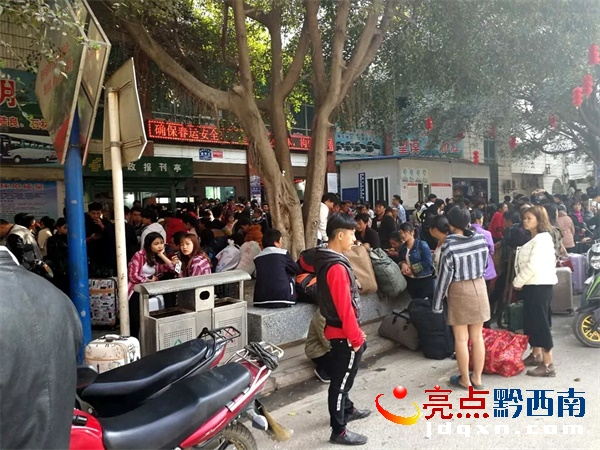 望謨車(chē)站站前街邊人行道占滿了旅客.jpg